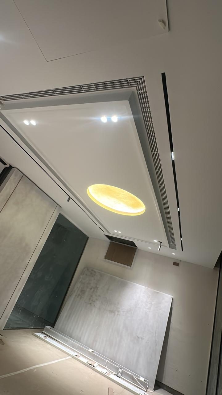 Stepped gypsum ceiling with a circular lit feature and linear air slots